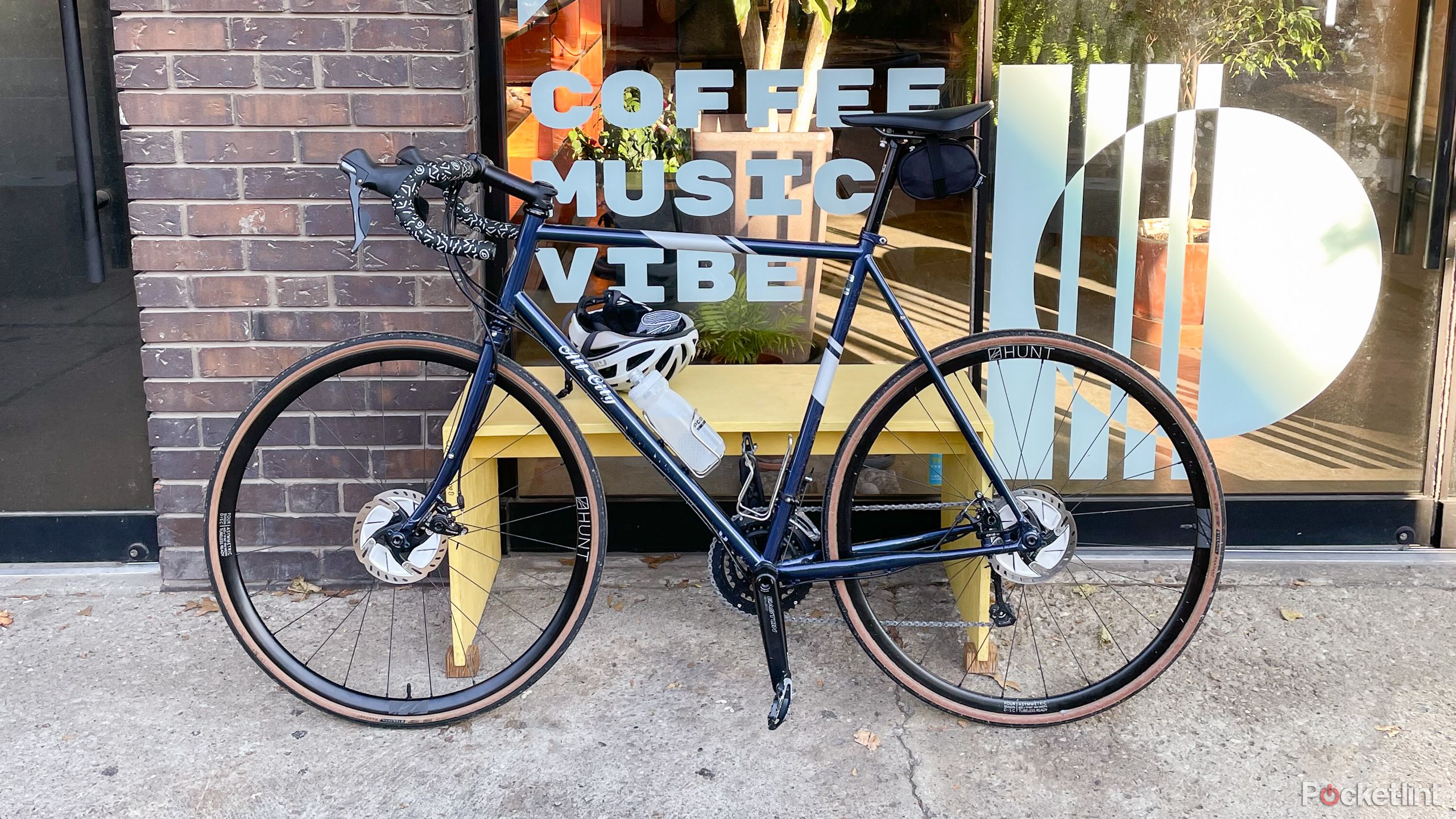 A steel blue bikes stands against a coffee shop