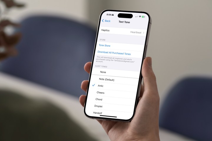 Someone holding an iPhone that shows the haptic setup screen for text tones.