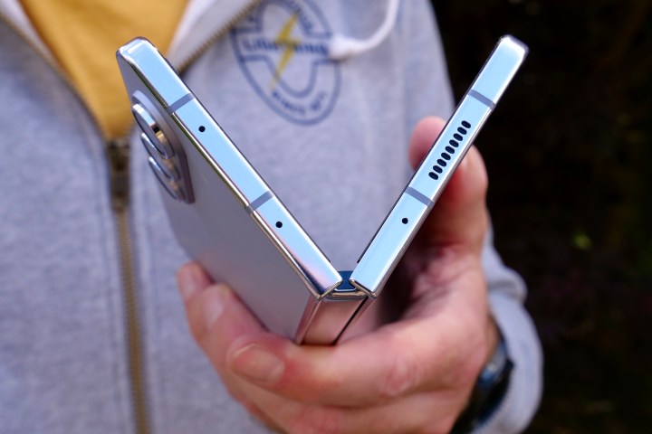 A person holding the Samsung Galaxy Z Fold 5, showing the top of the hinge.
