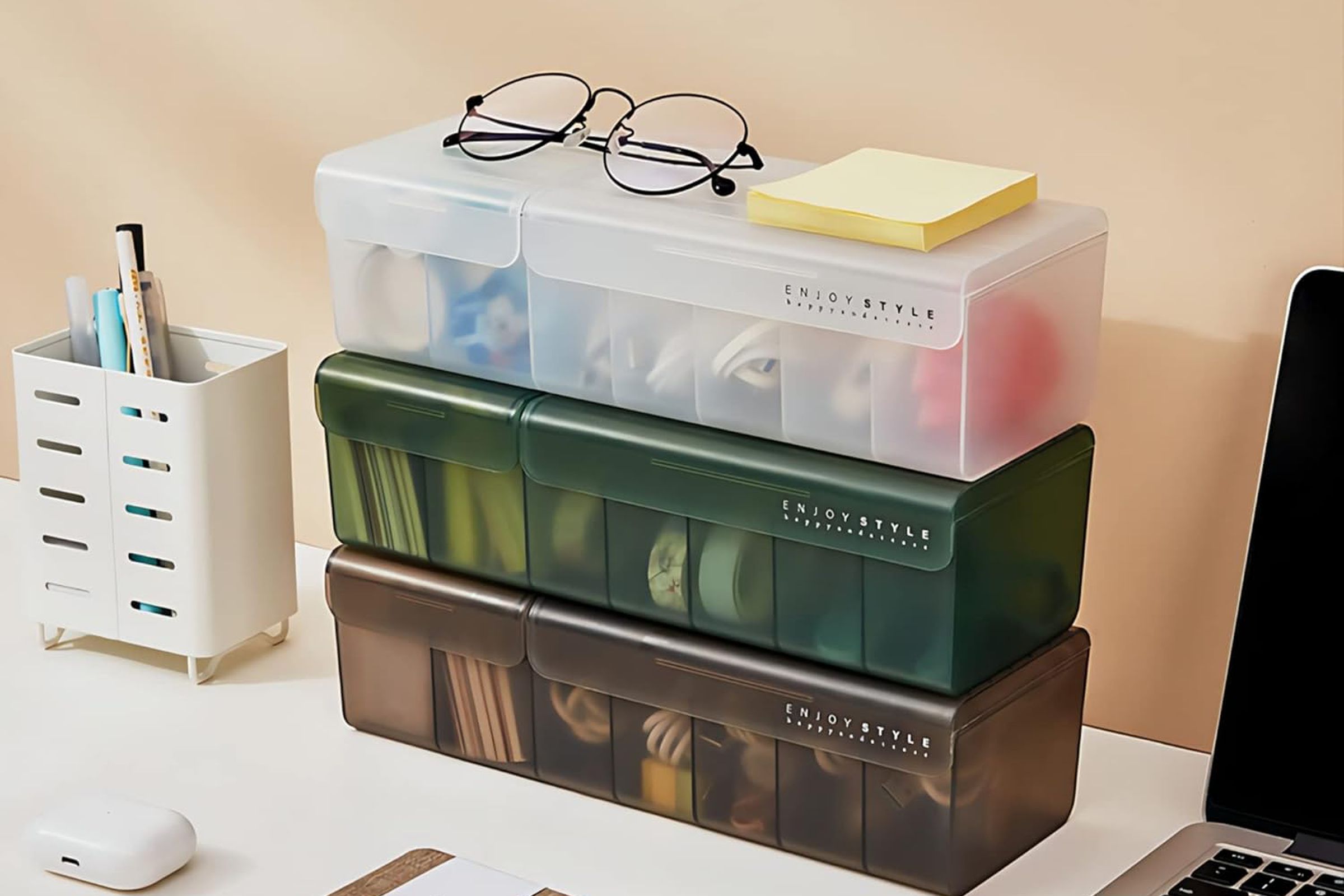 Three storage boxes piled on a desk.