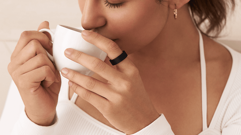 A person wearing the Ultrahuman Ring Air and drinking a coffee