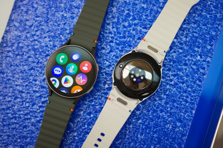 Two Samsung Galaxy Watch 7 smartwatches laying next to each other on a table.