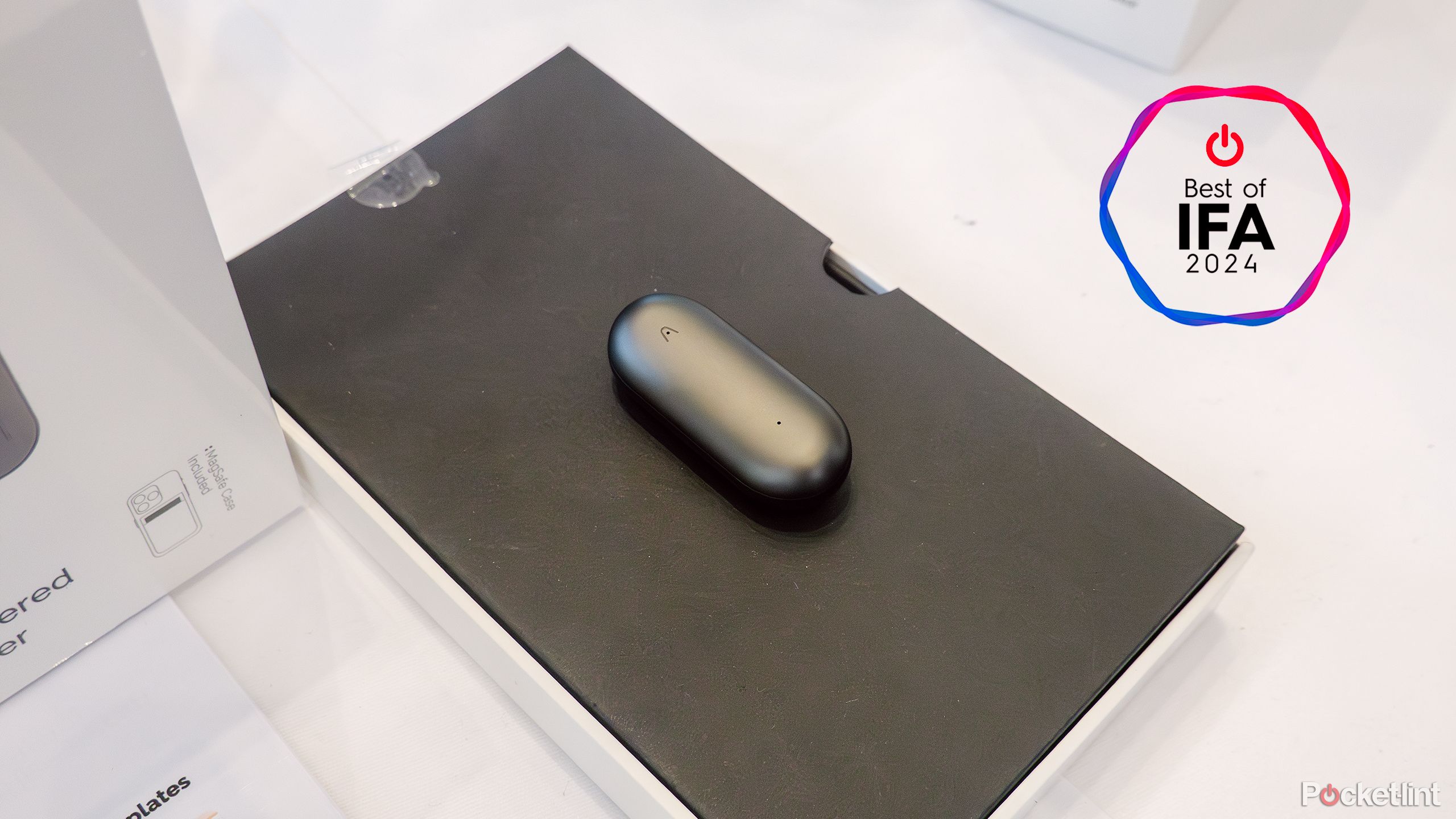 The PLAUD NotePin sits on a black pad on a display table. 