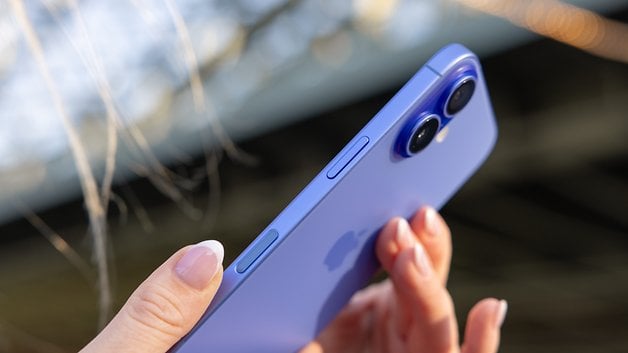 A person holding a purple iPhone 16, showcasing its rear design and dual cameras.