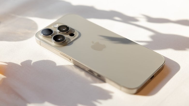 A close-up of an iPhone 16 Pro lying on a light surface with soft shadows.