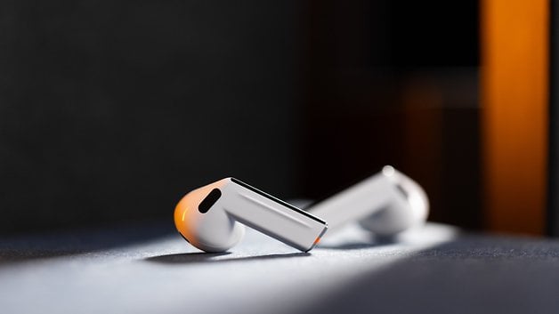 Samsung Galaxy Buds 3 wireless headphones resting on a surface with soft lighting.