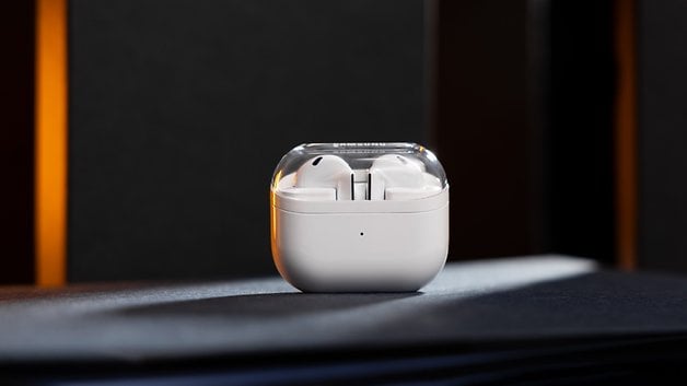 Samsung Galaxy Buds 3 in their charging case, placed on a dark surface.