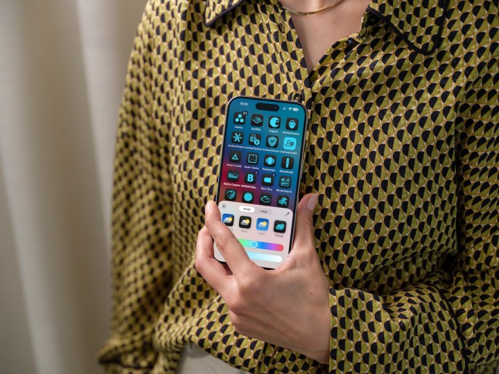 Person holding an iPhone showing new home screen customization tools on iOS 18.