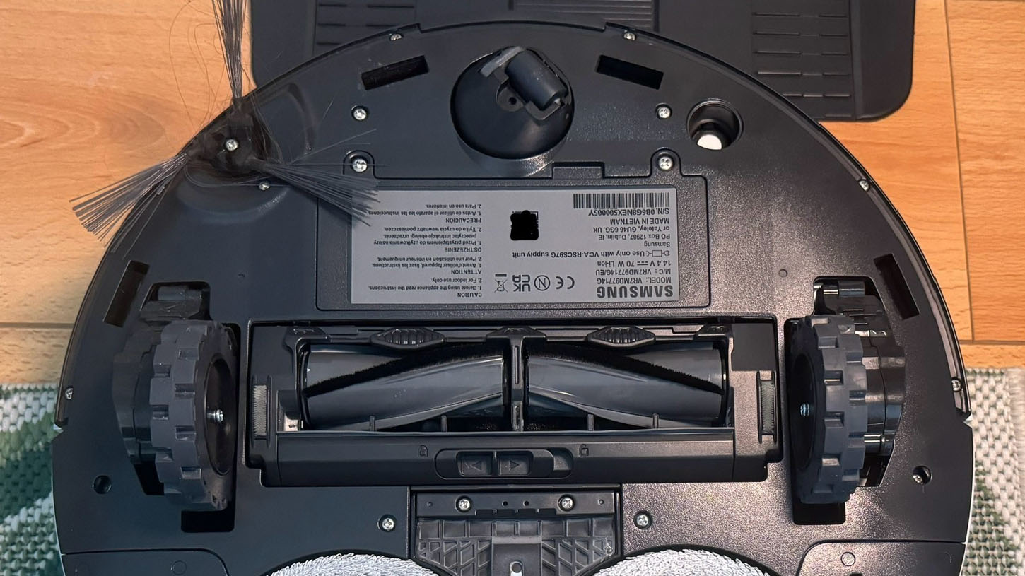 Underside of Samsung Jet Bot Combo AI robot vacuum, showing rollers and side brush