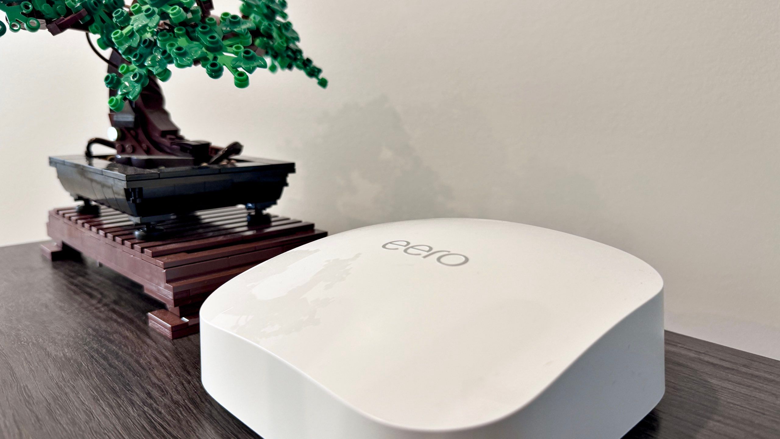 An Eero Pro 6e next to a Lego bonsai tree. 