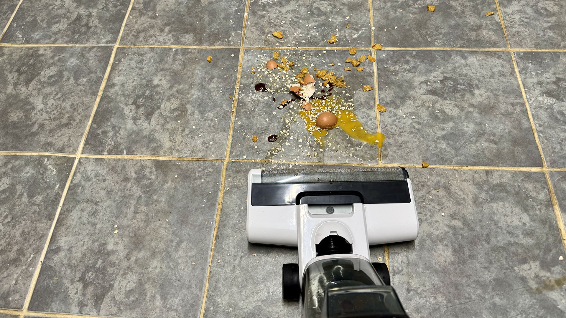 Gtech Orca hard floor cleaner approaching a food spillage including eggs and oats