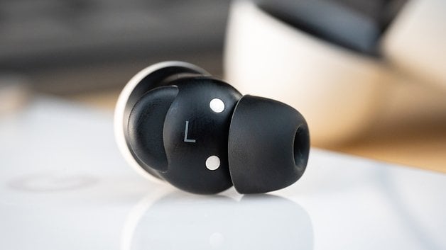 Close up of a black Google Pixel Buds Pro 2 earbud with the letter 'L' and two white dots.