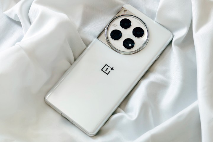 OnePlus 12 Glacial White on a wrinkly satin white cloth.