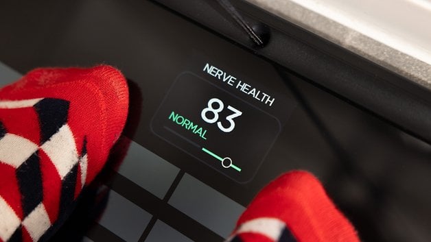 A close-up of a scale displaying 'Nerve Health 83 Normal' with colorful socks in view.