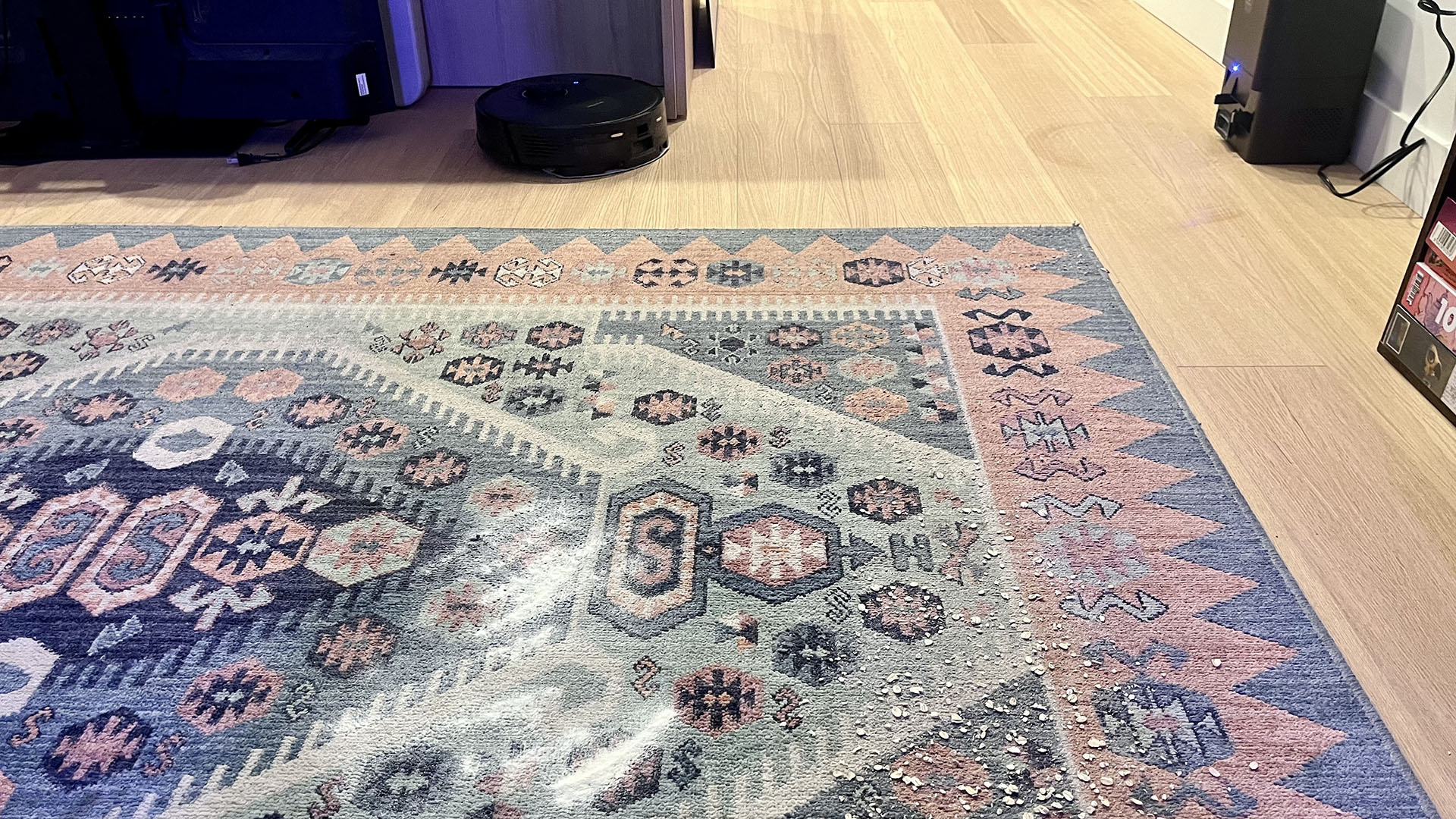 Flour and oats sprinkled on a rug, with Proscenic Q8 Max robot vacuum nearby