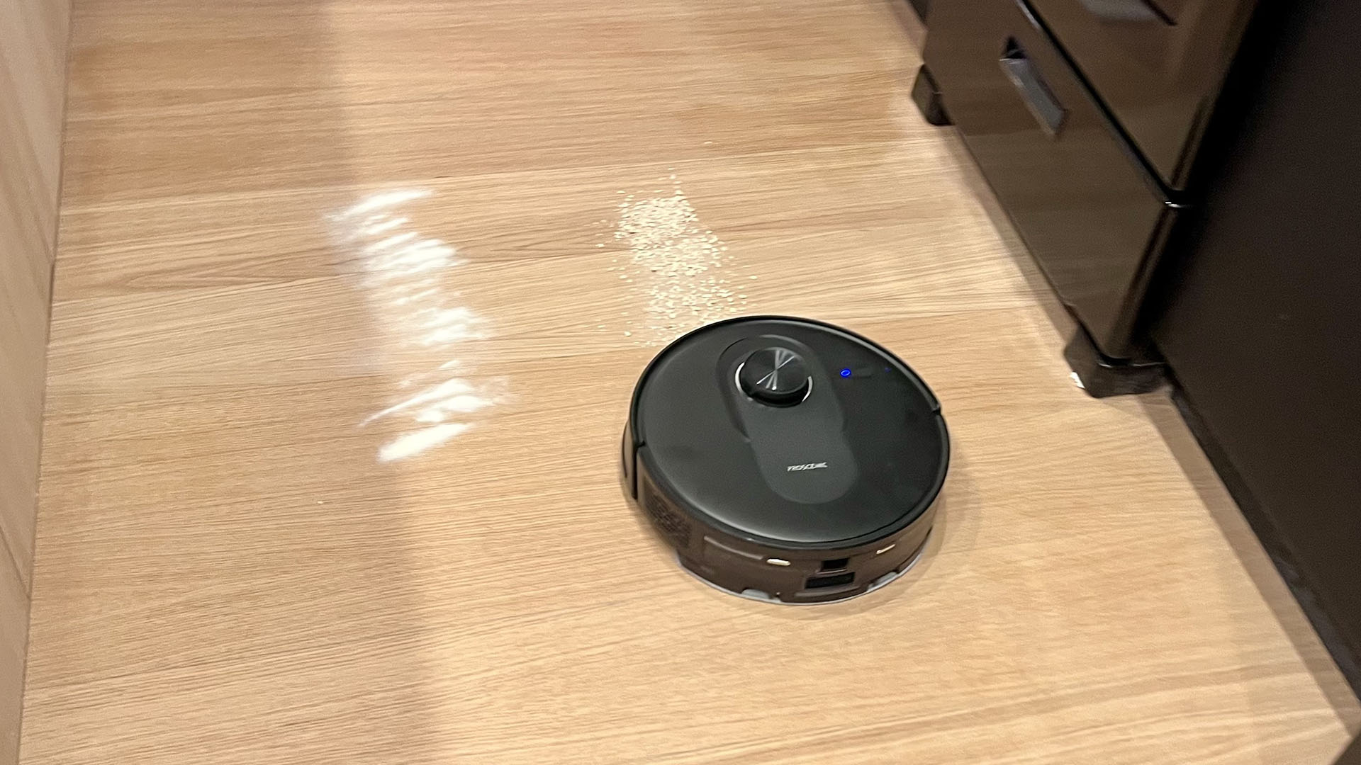 Proscenic Q8 Max robot vacuum in the process of clearing oats from hard floor