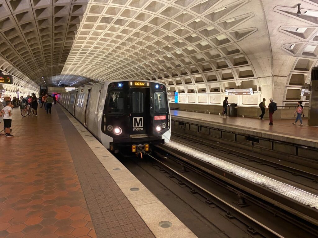 A yellow line metro train arrives at an underground station