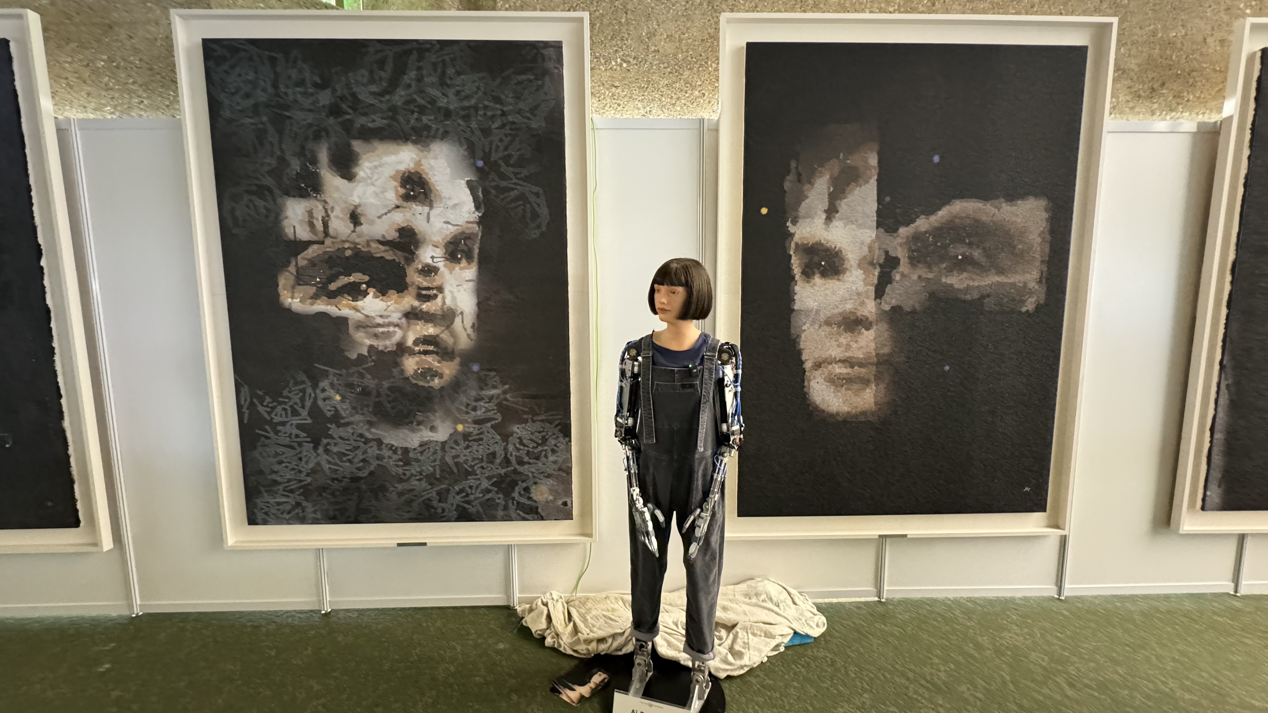 The Ai-Da robot standing in front of her 'AI God' painting on Alan Turing