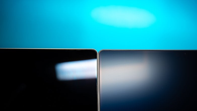 Close-up of two Apple MacBook Pro screens against a blue background.