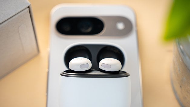 Close-up of the Google Pixel Buds Pro 2 in their charging case on a wooden surface.